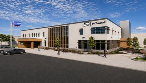 Exterior view of a modern two‑story building with CTtransit and CTDOT signage, light‑colored walls, large windows, and landscaped walkways, with several people and parked cars in front under a partly cloudy sky.